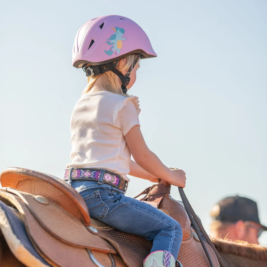 Niña con casco Troxel Youngster lila montando a caballo, vista de perfil