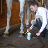 Persona aplicando Hooflex Therapeutic Conditioner Liquid en el casco de un caballo