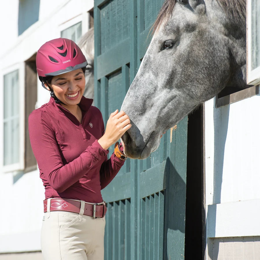 Amazona con casco Troxel Intrepid vino junto a un caballo tordo