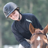 Retrato de amazona con casco Troxel Liberty negro junto a su caballo