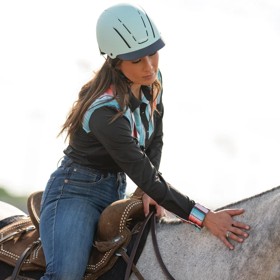 Amazona con casco Troxel Spirit menta Duratec acariciando a su caballo