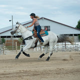 Amazona con casco Troxel Liberty negro saltando un obstáculo a caballo