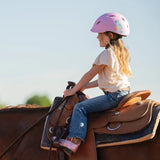 Niña con casco Troxel Youngster lila montando a caballo, vista de espaldas
