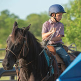 Niña con casco Troxel Spirit azul marino montando un caballo oscuro
