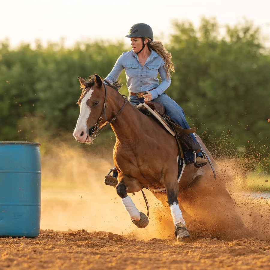 Amazona con casco Troxel Liberty negro Duratec montando en una prueba de barriles