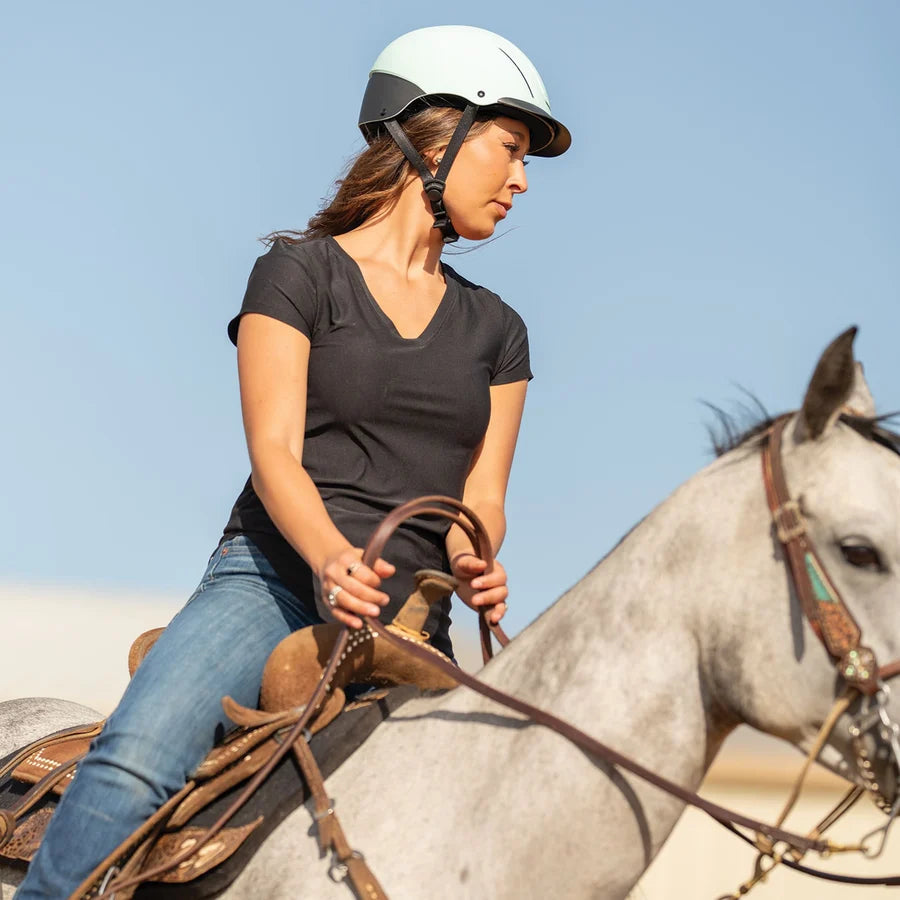 Amazona con casco Troxel Spirit menta Duratec montando un caballo tordo