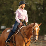 Amazona con camisa rosa y casco Troxel Spirit MIPS negro montando un caballo palomino